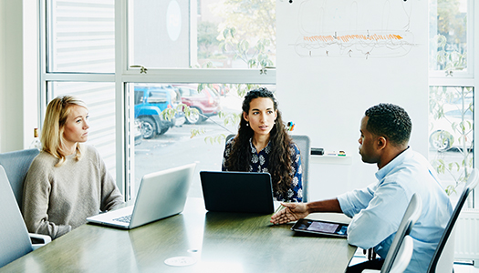 A group of people sitting in a conference room and engrossed in a discussion