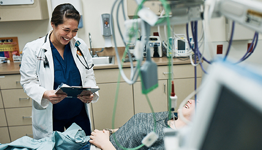 A physician laughing with a patient during a physical exam